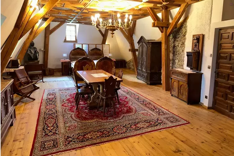 Großzügiger historischer Raum mit Holzbalken und Sitzgruppe
